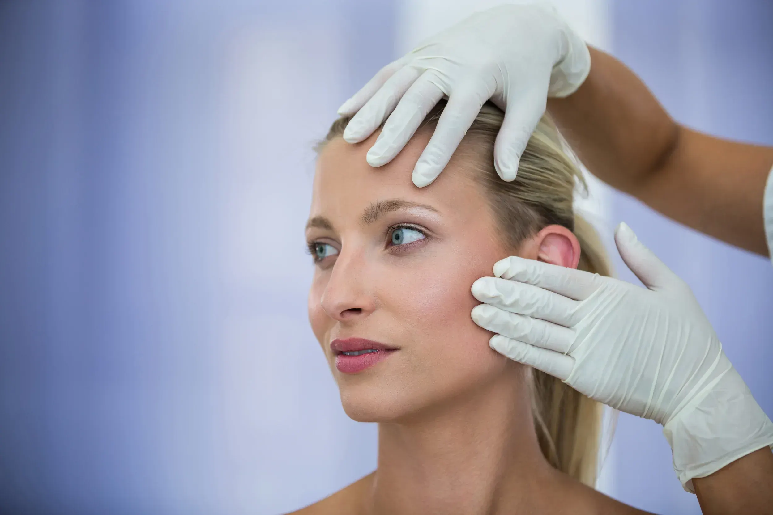Doctor examining patient face for Radiesse dermal filler treatment